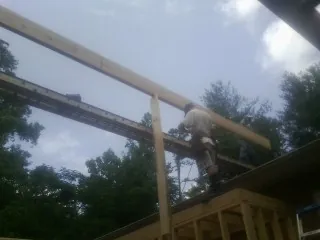 Carpenter setting a ridge beam over a new addition frame — Ice Dam Removal by Roofing Brothers in Andersonville