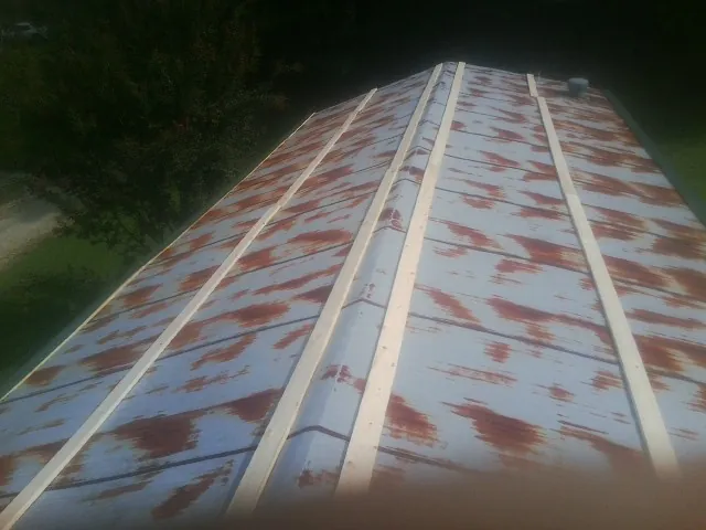 Rusted metal roof panels with new wood purlins before replacement — Storm Damage Roof Repair in Andersonville by Roofing Brothers