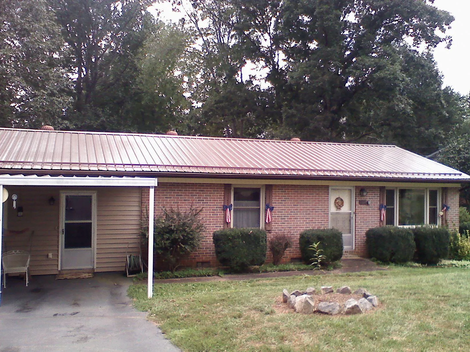 Bronze metal roof and carport on a brick ranch home — Roof Repair work by our crew in Andersonville