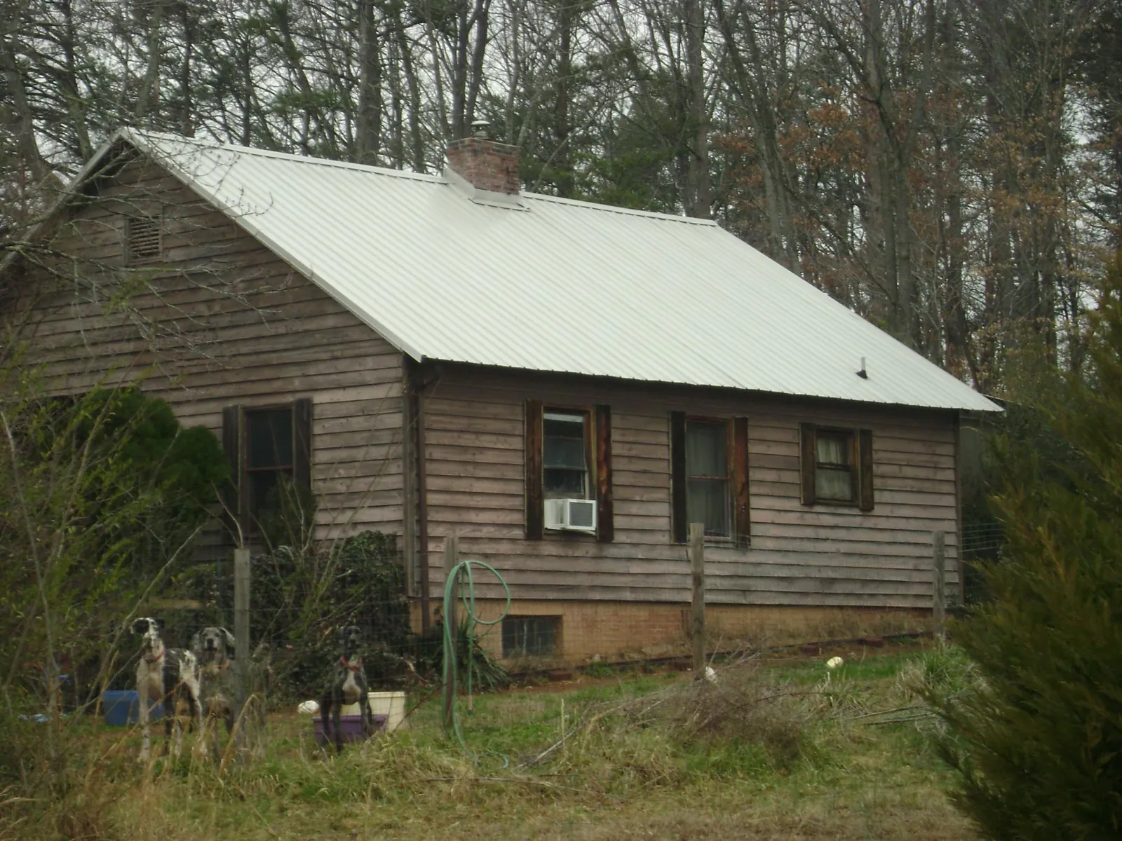 White metal roof on an old wood sided farmhouse, from a Metal Roof Installation job in Andersonville
